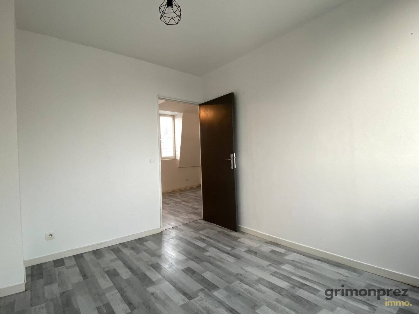 Chambre du T2 bis avec parquet gris et porte marron