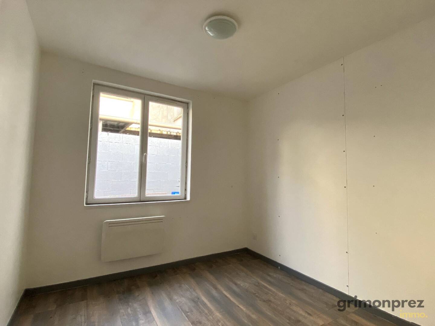 Cuisine moderne du T2 bis avec meubles blancs et carrelage bleu