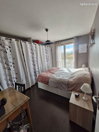 Chambre de l'appartement avec baie vitrée donnant sur balcon