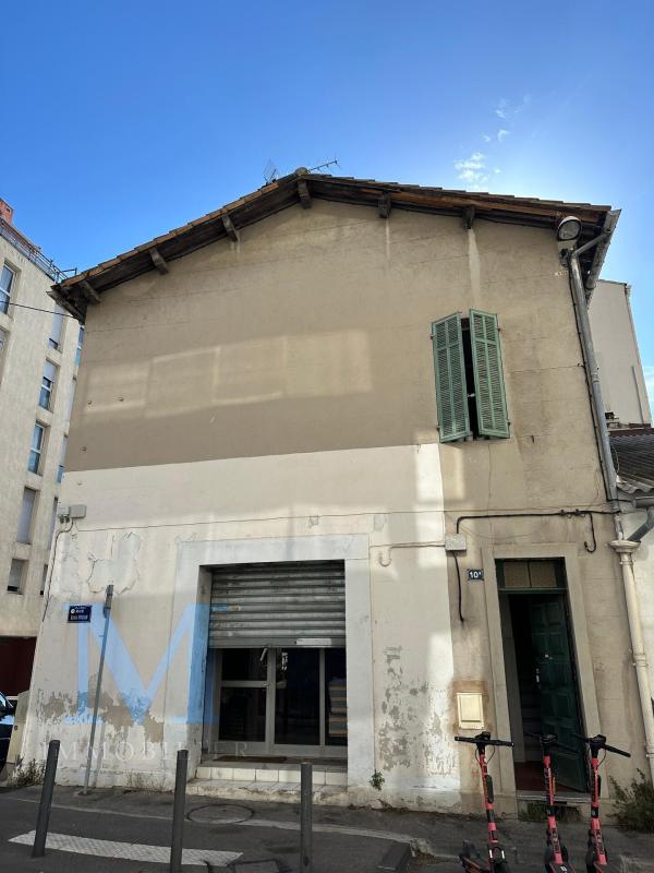 Façade de l'immeuble depuis la rue, enduit dégradé