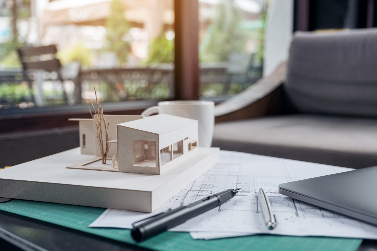 Un modèle architectural et un papier à dessin posés sur une table