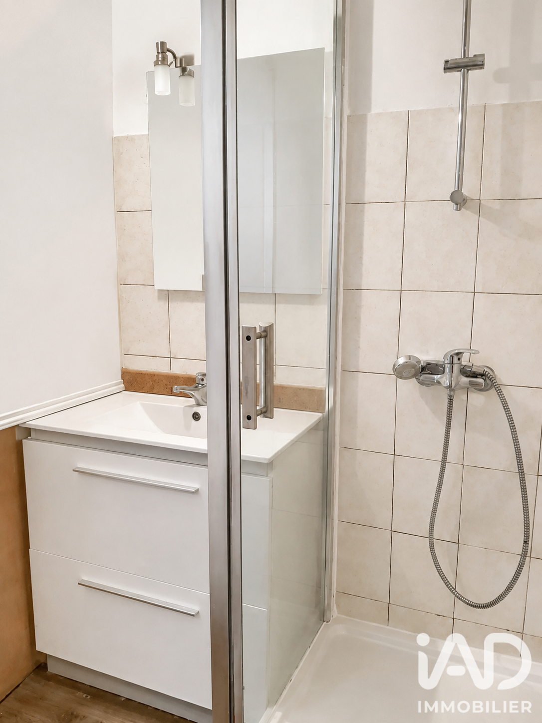 Salle d'eau récente d'un T2 avec cabine douche italienne et meuble vasque blanc