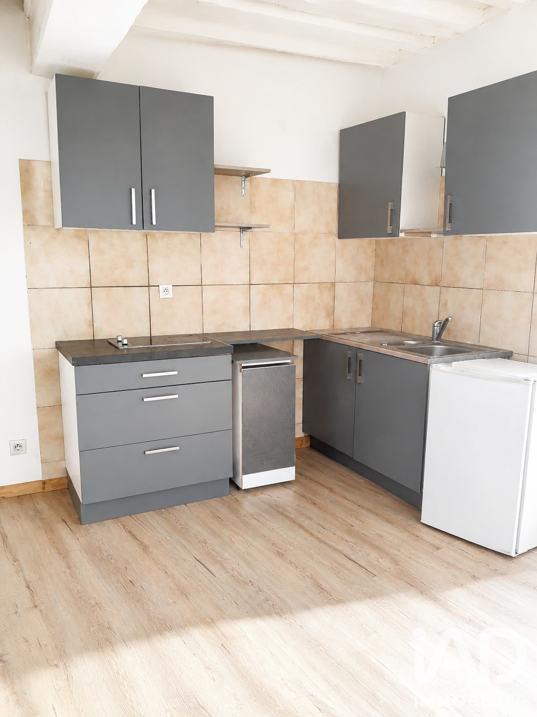 Cuisine équipée moderne d'un T2 avec meubles gris anthracite et plaque induction