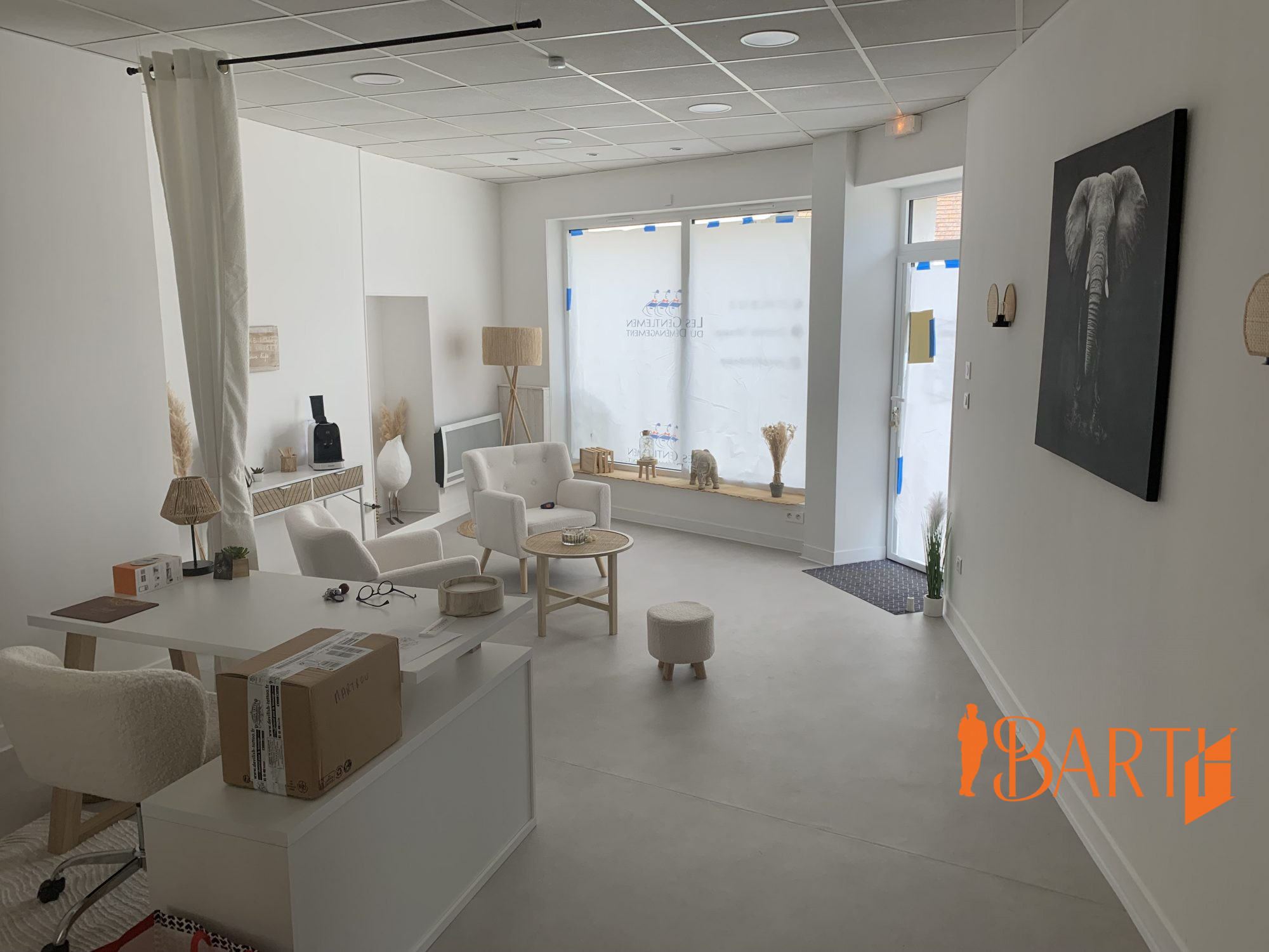 Espace d'accueil avec bureau et coin salon d'attente