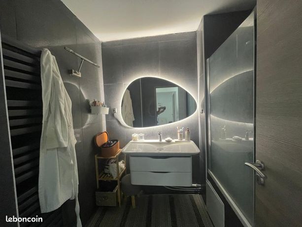 Salle de bain rénovée avec miroir rétro-éclairé