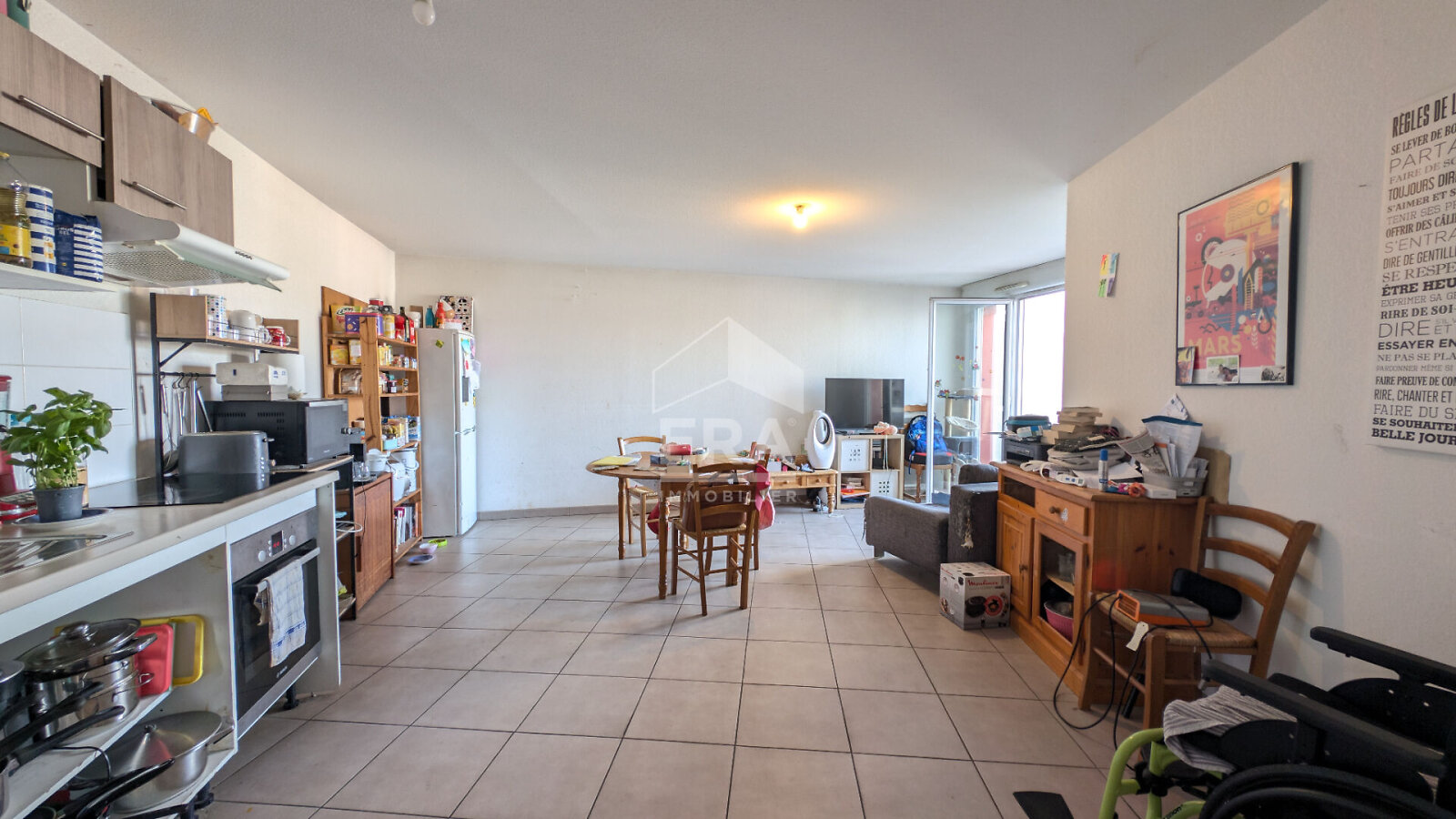 Pièce de vie avec cuisine ouverte et carrelage beige